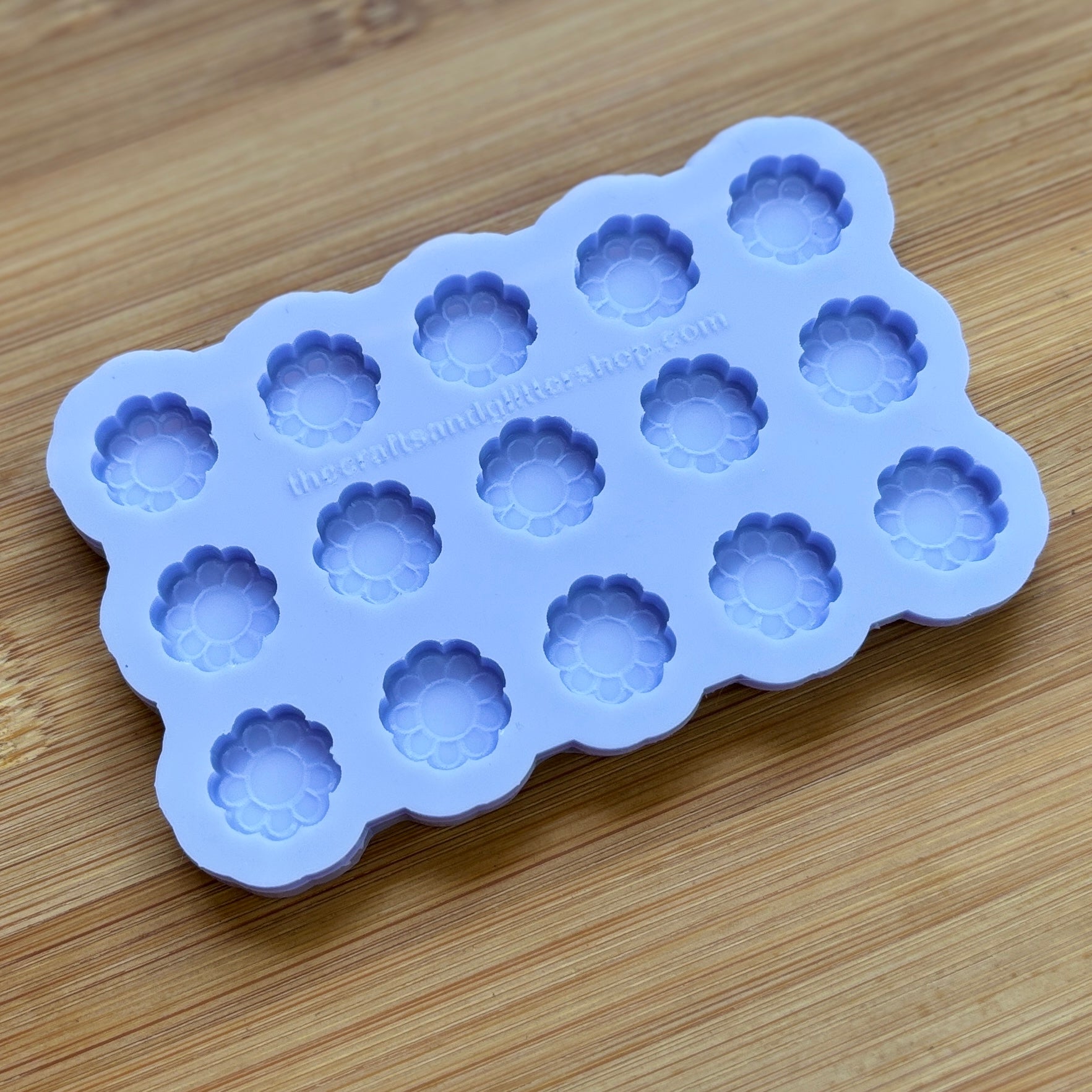Silicone mold with flower-shaped cavities on a wooden surface