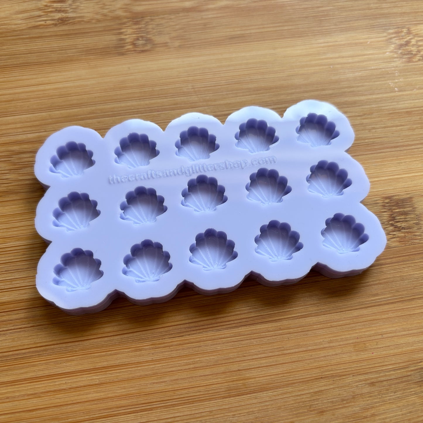 Silicone mold with shell-shaped cavities on a wooden surface