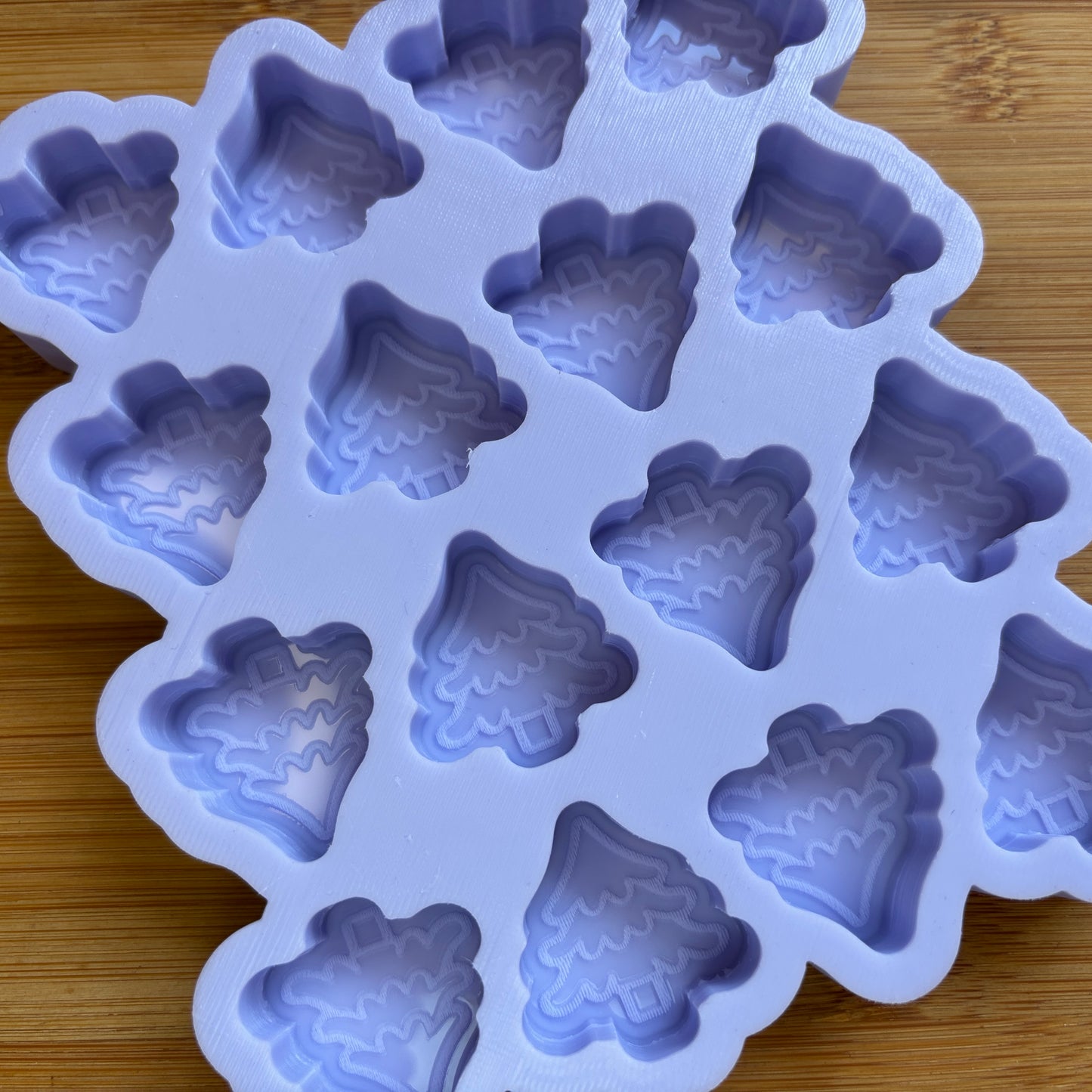 Silicone mold with tree-shaped cavities on a wooden surface