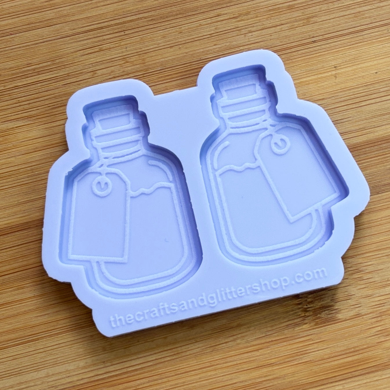 Silicone mold shaped like bottles on a wooden surface