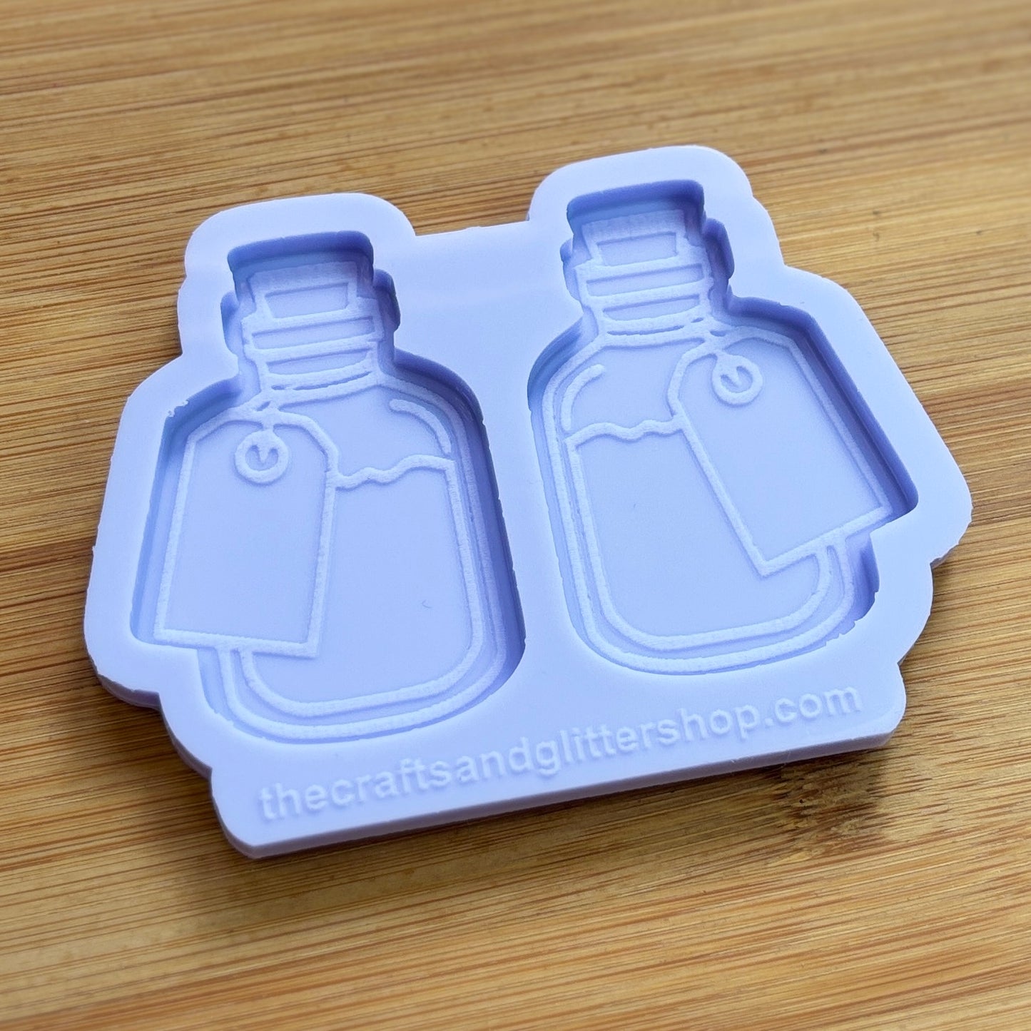 Silicone mold shaped like two bottles on a wooden surface