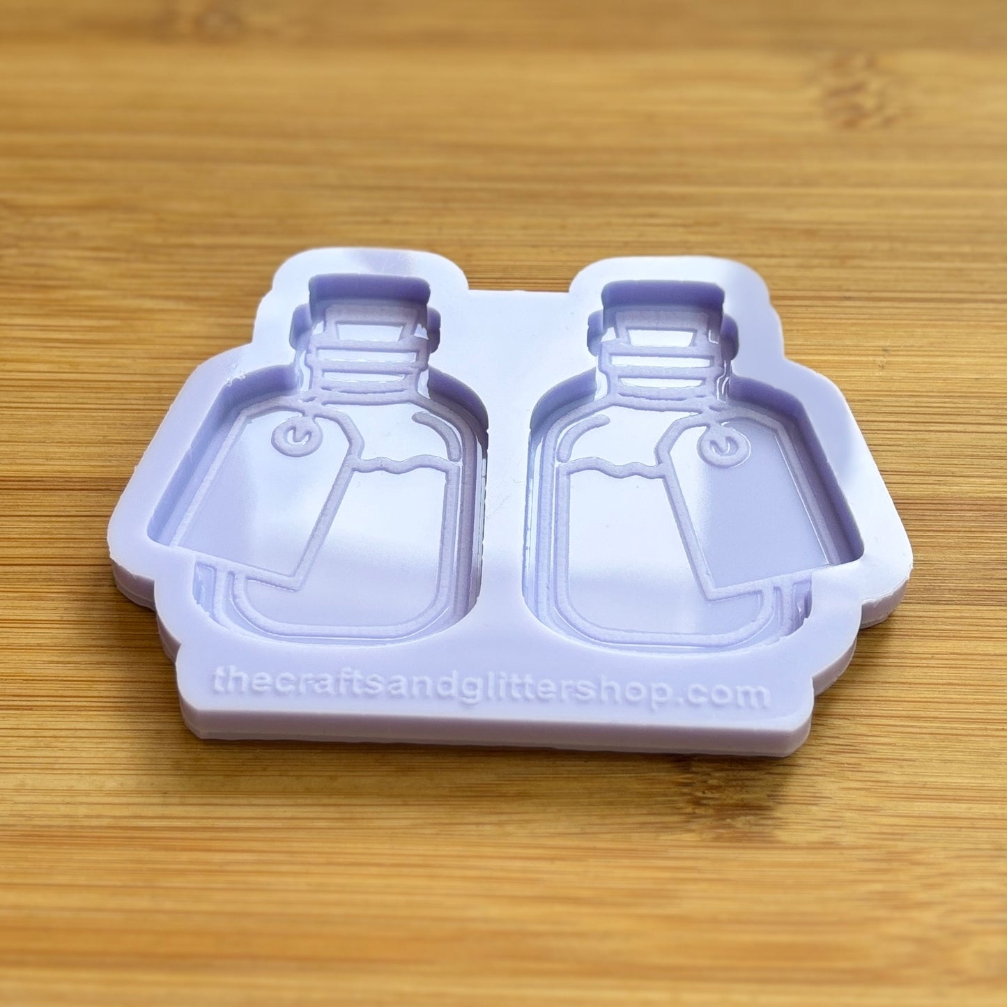 Silicone mold shaped like bottles on a wooden surface
