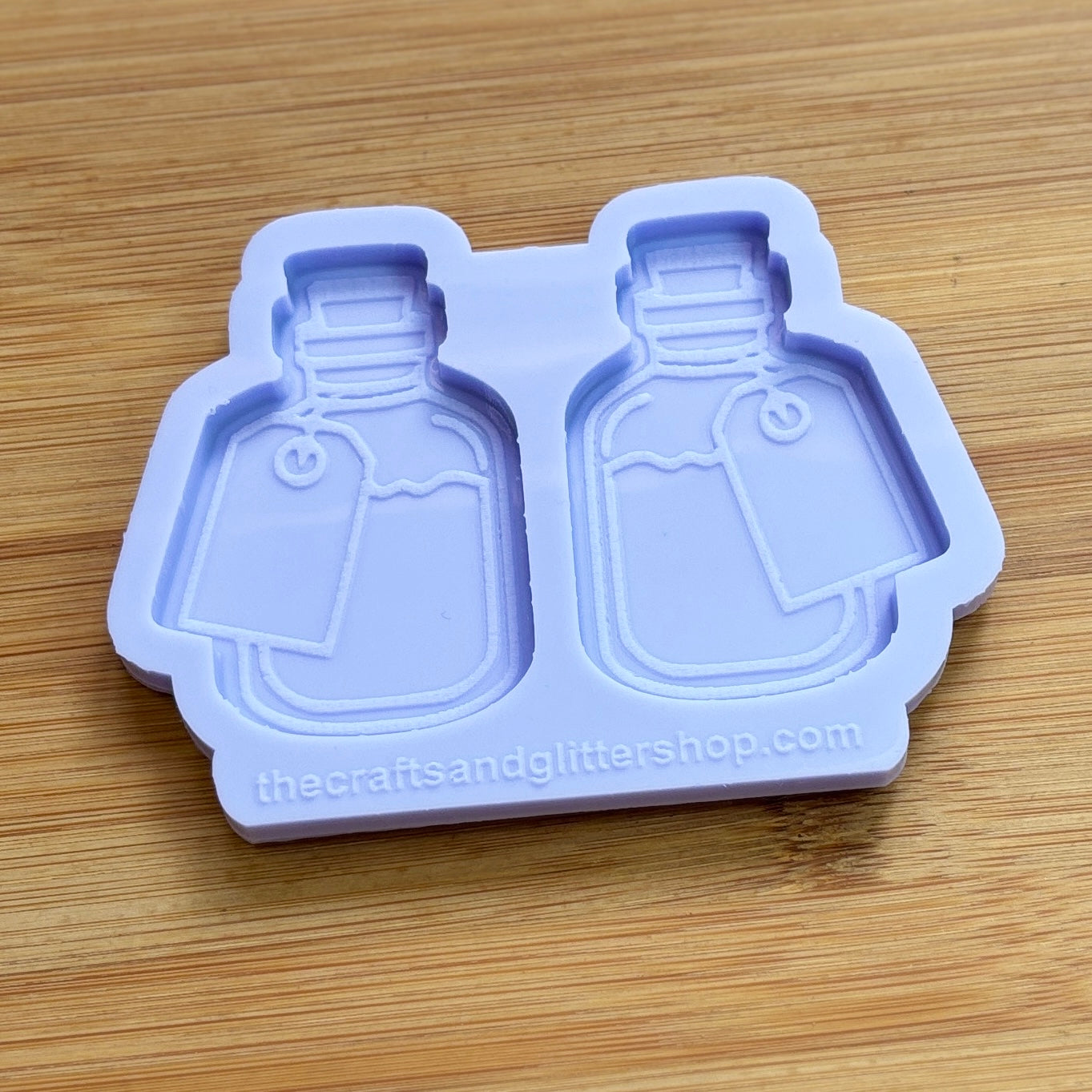 Silicone mold shaped like two bottles on a wooden surface