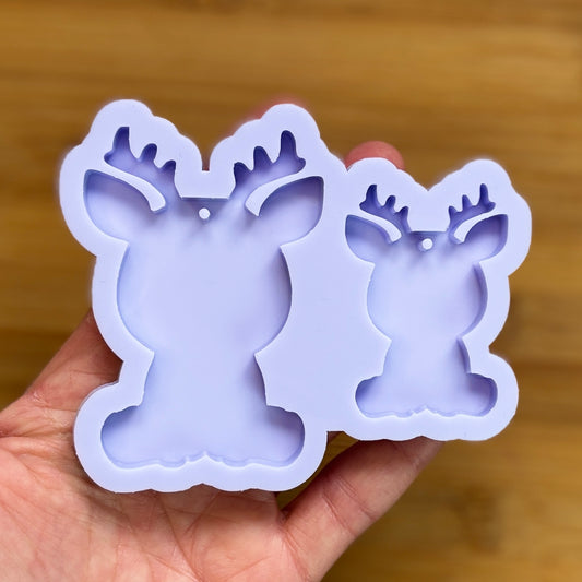 Reindeer silhouette Silicone Mold with 2 cavities of different sizes. The cavity has a hole in it. The mols is made with Food Safe Silicone suitable for both food and craft projects.