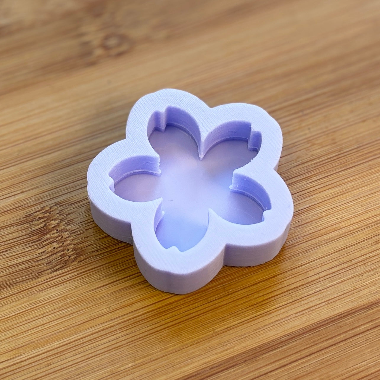 Flower-shaped silicone mold on a wooden surface