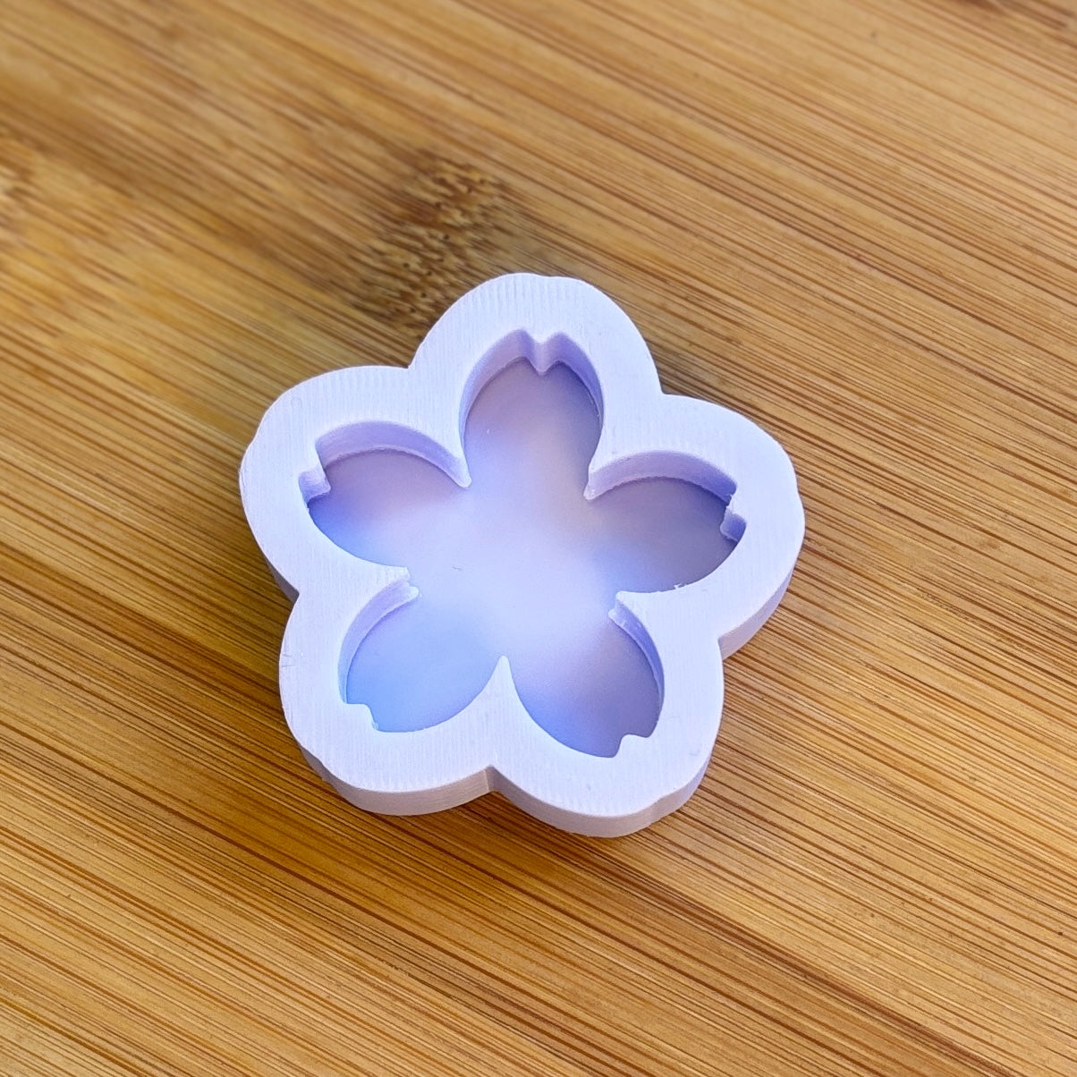 Flower-shaped silicone mold on a wooden surface