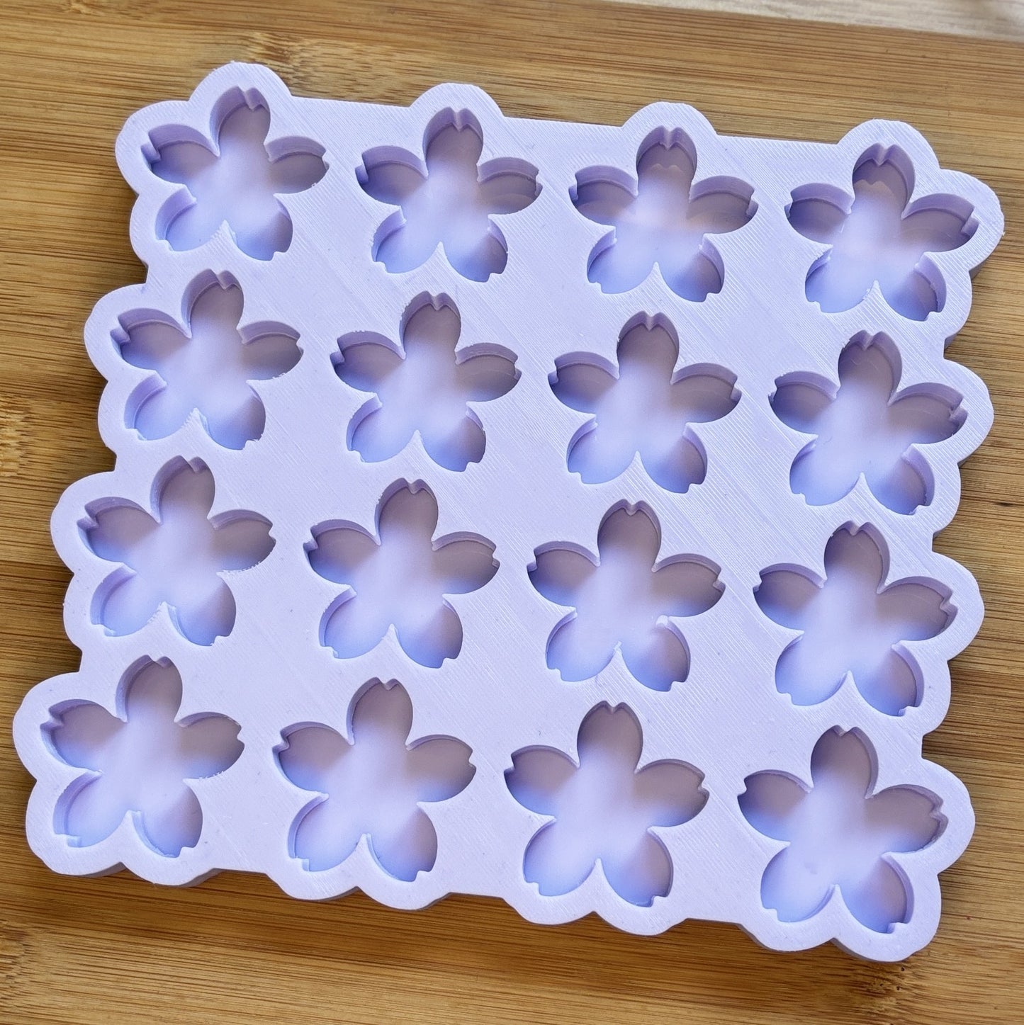 Silicone mold with flower shapes on a wooden surface