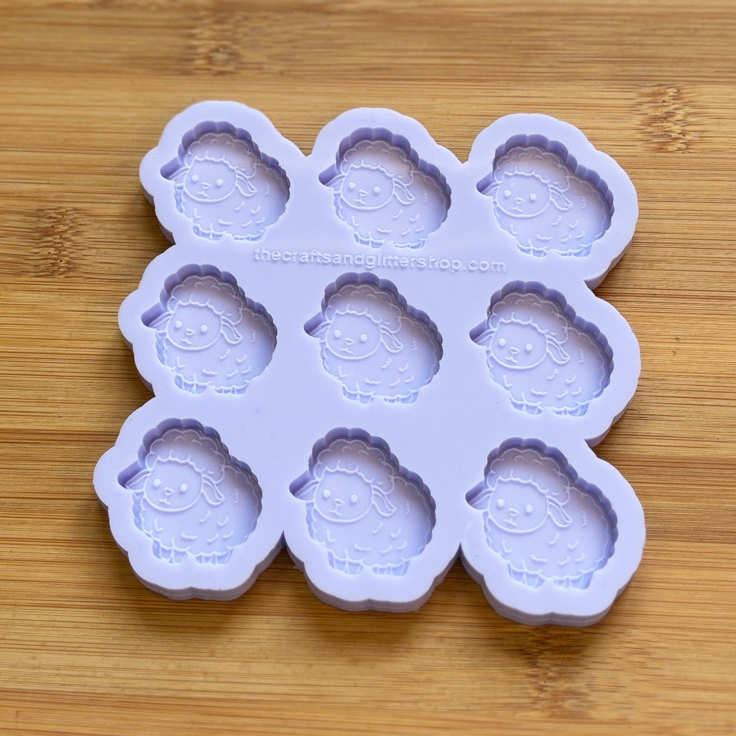 Silicone mold with sheep shapes on a wooden surface
