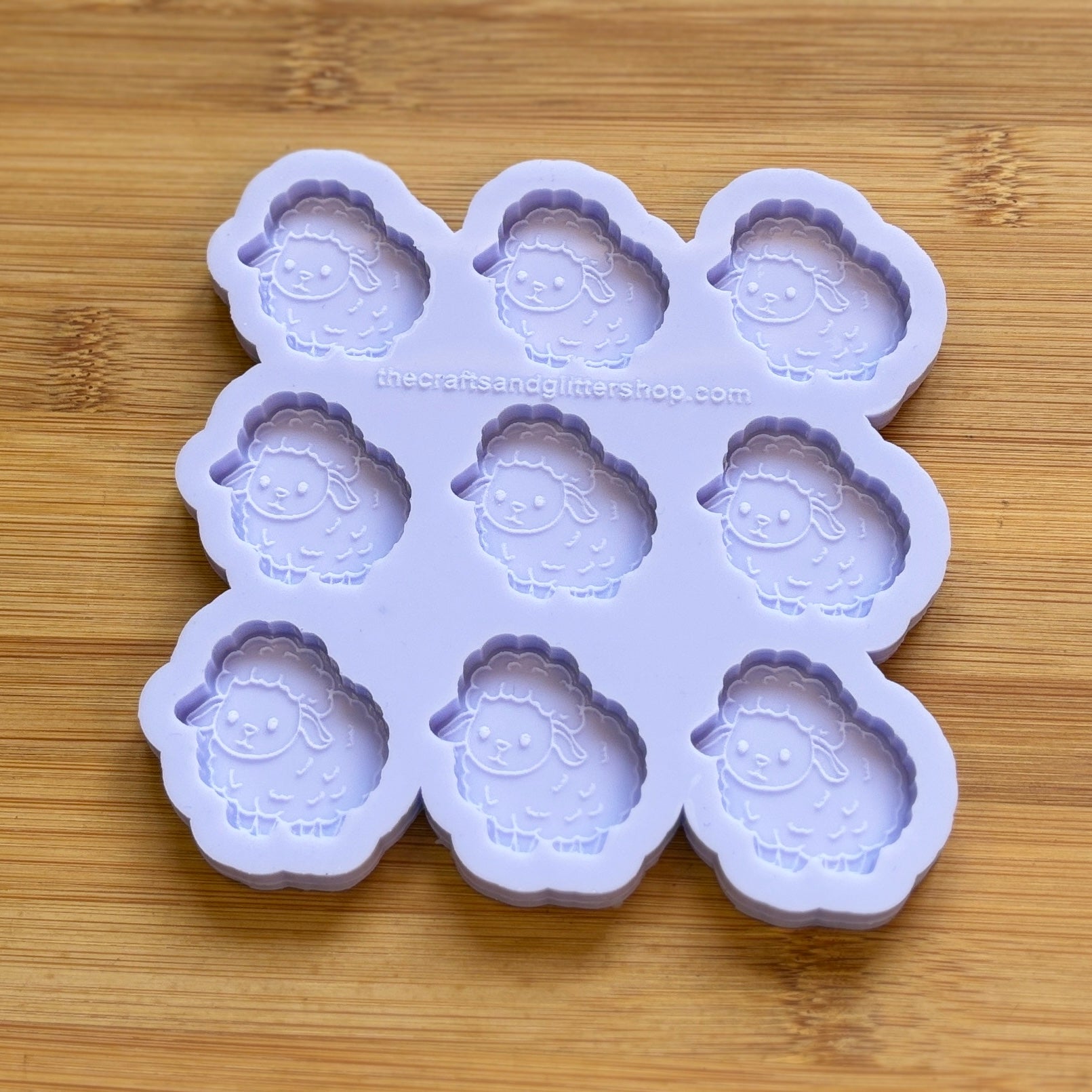 Silicone mold with sheep shapes on a wooden surface