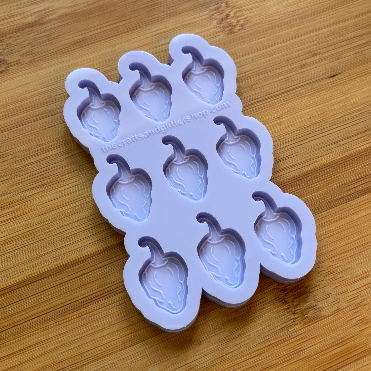 Silicone mold with habanero-shaped cavities on a wooden surface