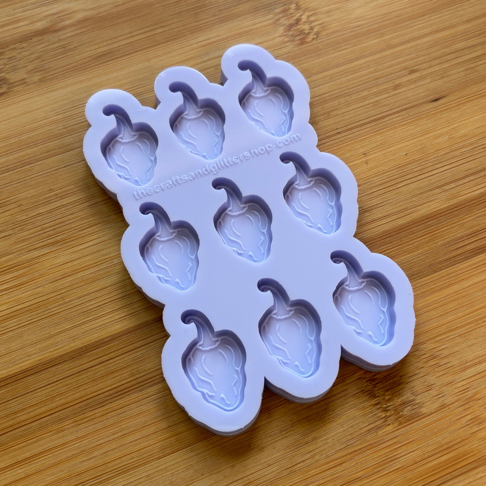 Silicone mold with habanero-shaped cavities on a wooden surface