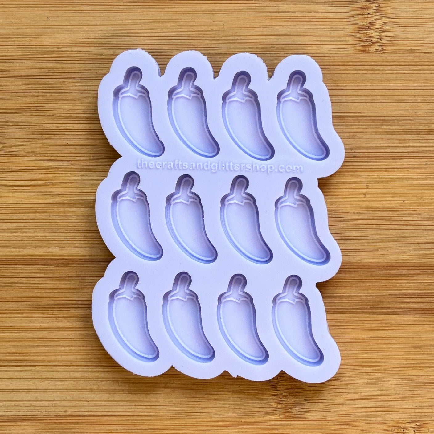 Silicone mold with jalapeno pepper shapes on a wooden surface