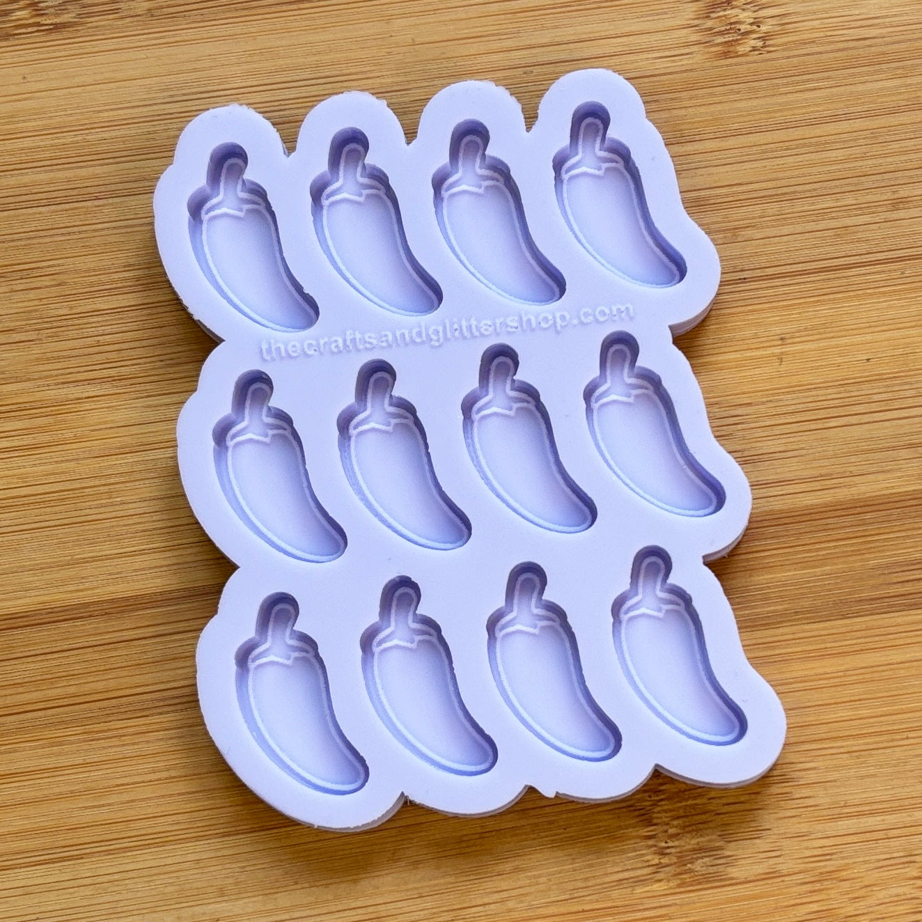 Silicone mold with jalapeno pepper shapes on a wooden surface
