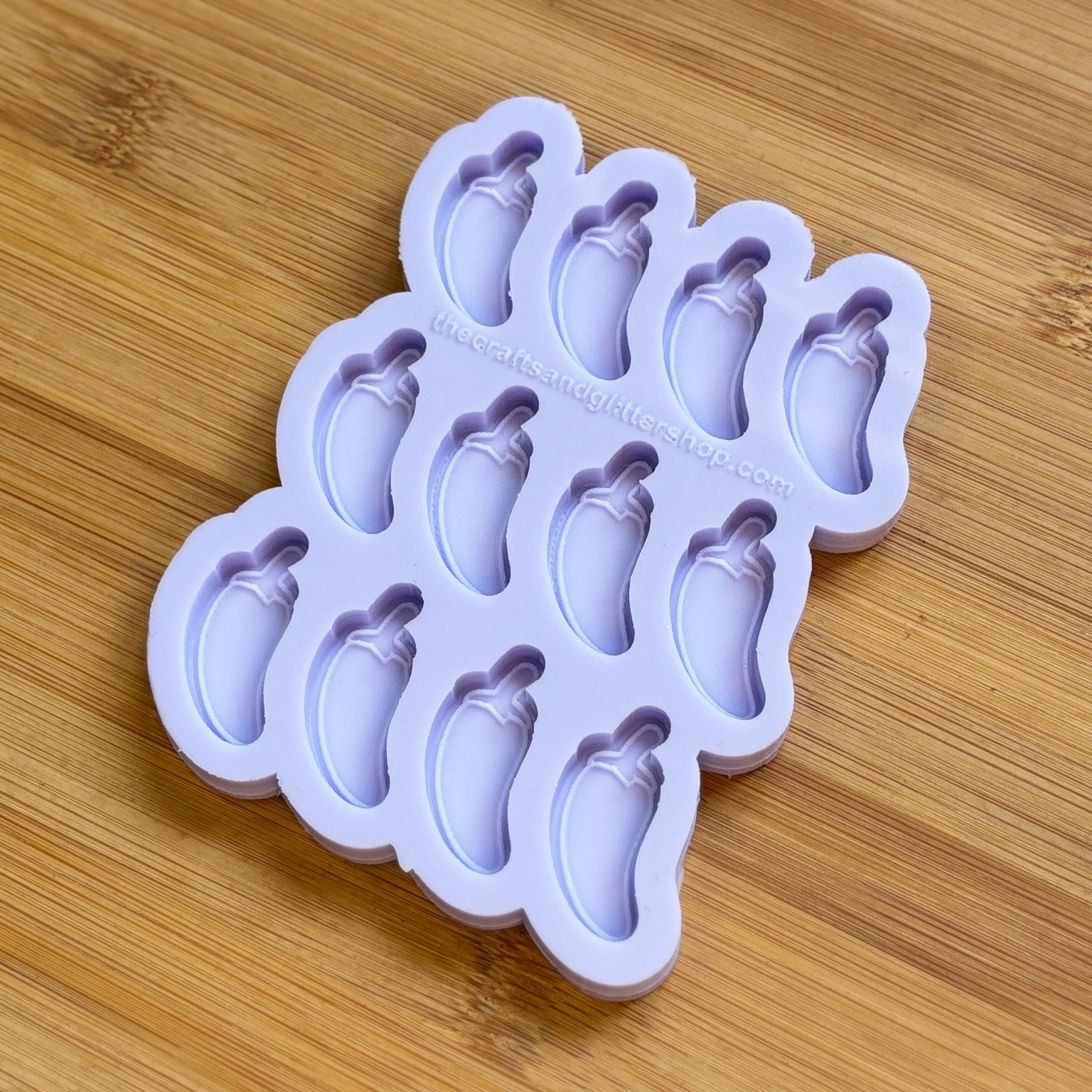 Silicone mold with multiple cavity jalapeno shapes on a wooden surface