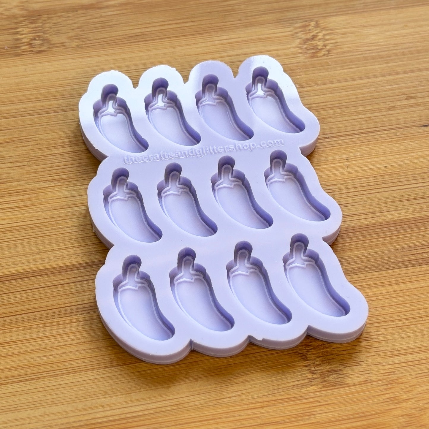 Silicone mold with jalapeno pepper shapes on a wooden surface