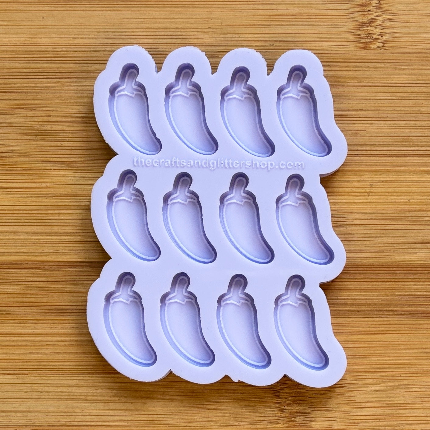 Silicone mold with jalapeno pepper shapes on a wooden surface