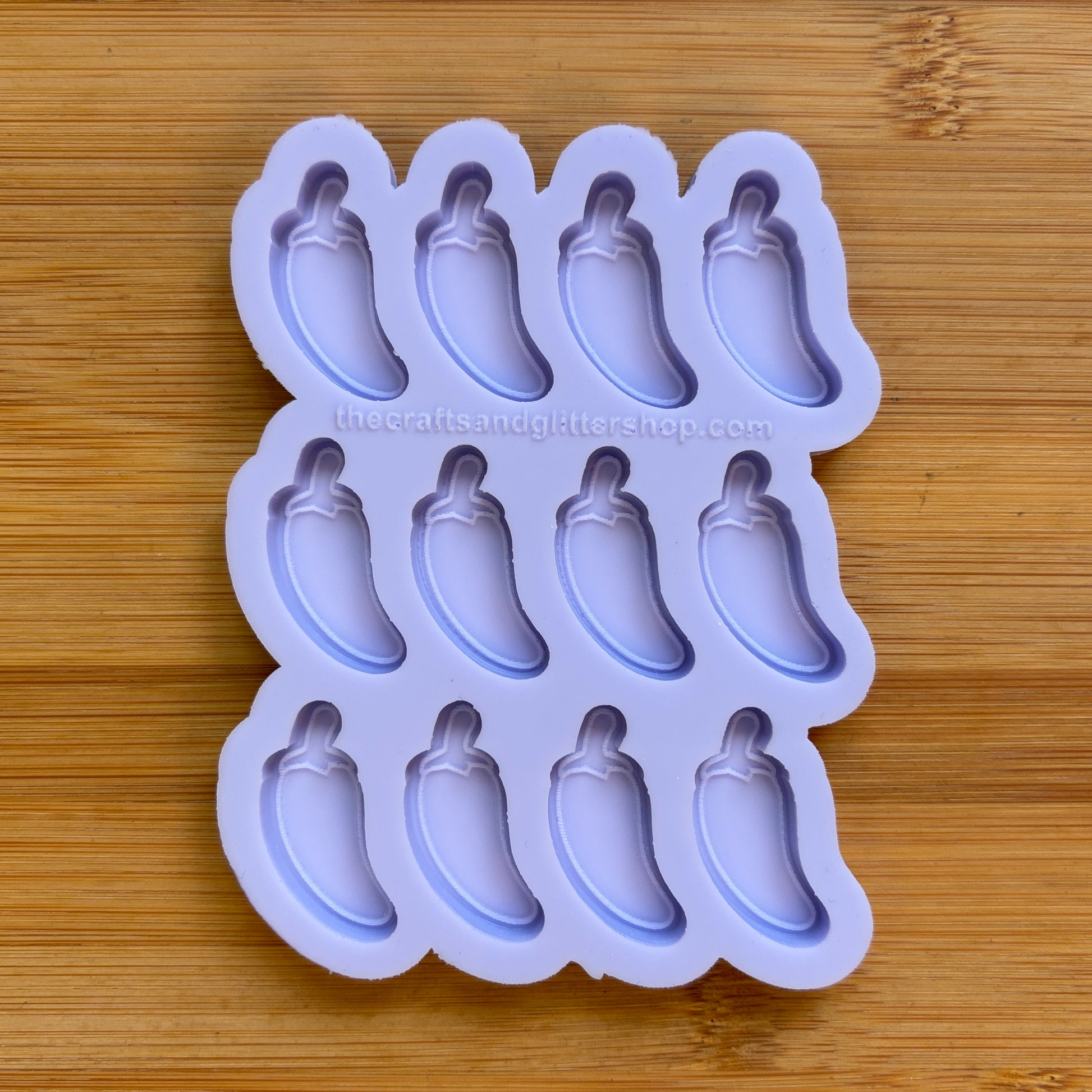 Silicone mold with jalapeno pepper shapes on a wooden surface
