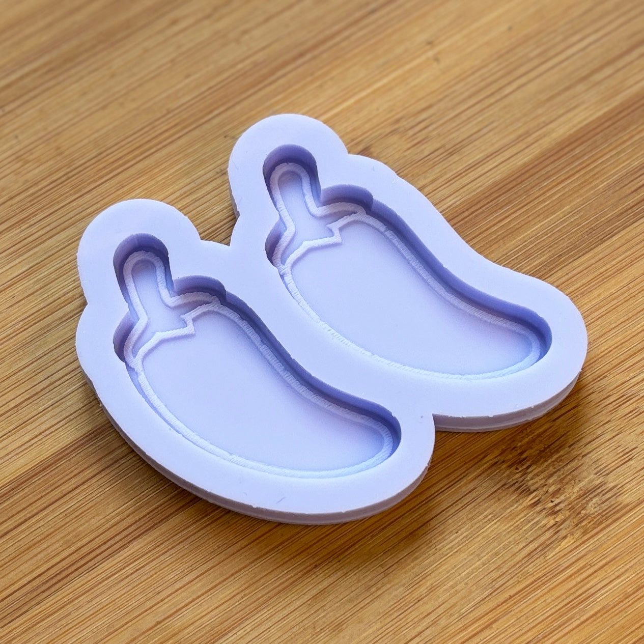 Silicone mold shaped like a bell pepper on a wooden surface