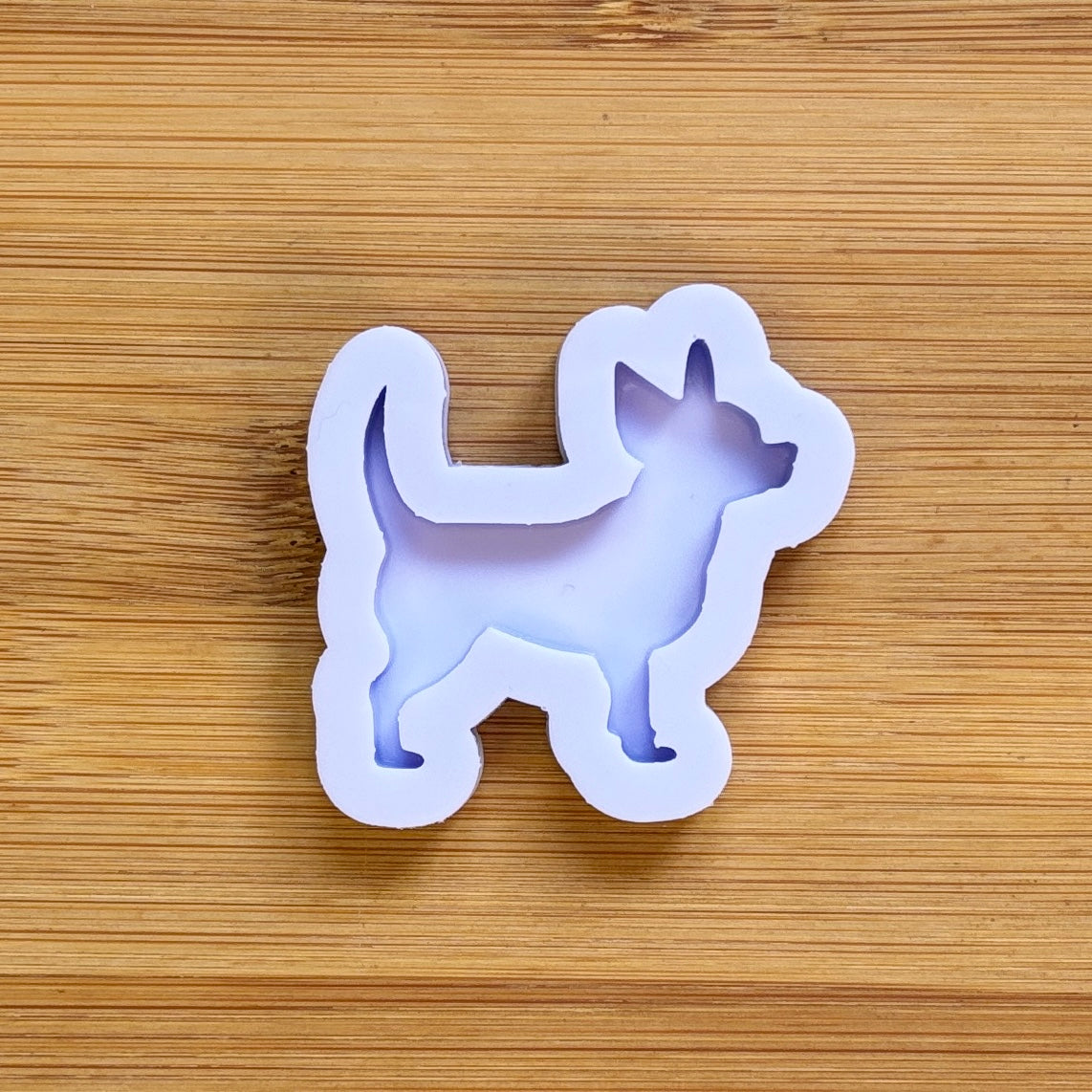 Silicone mold shaped like a dog on a wooden surface