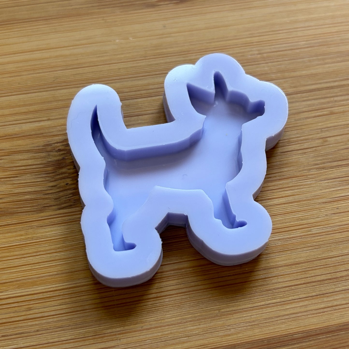Silicone mold shaped like a dog on a wooden surface