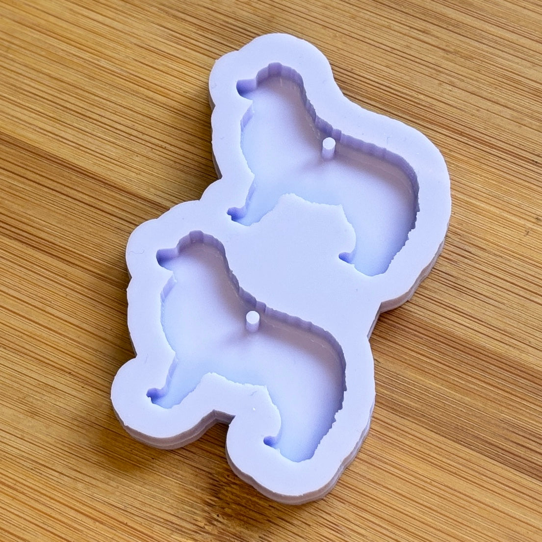 Silicone mold shaped like a dog on a wooden surface