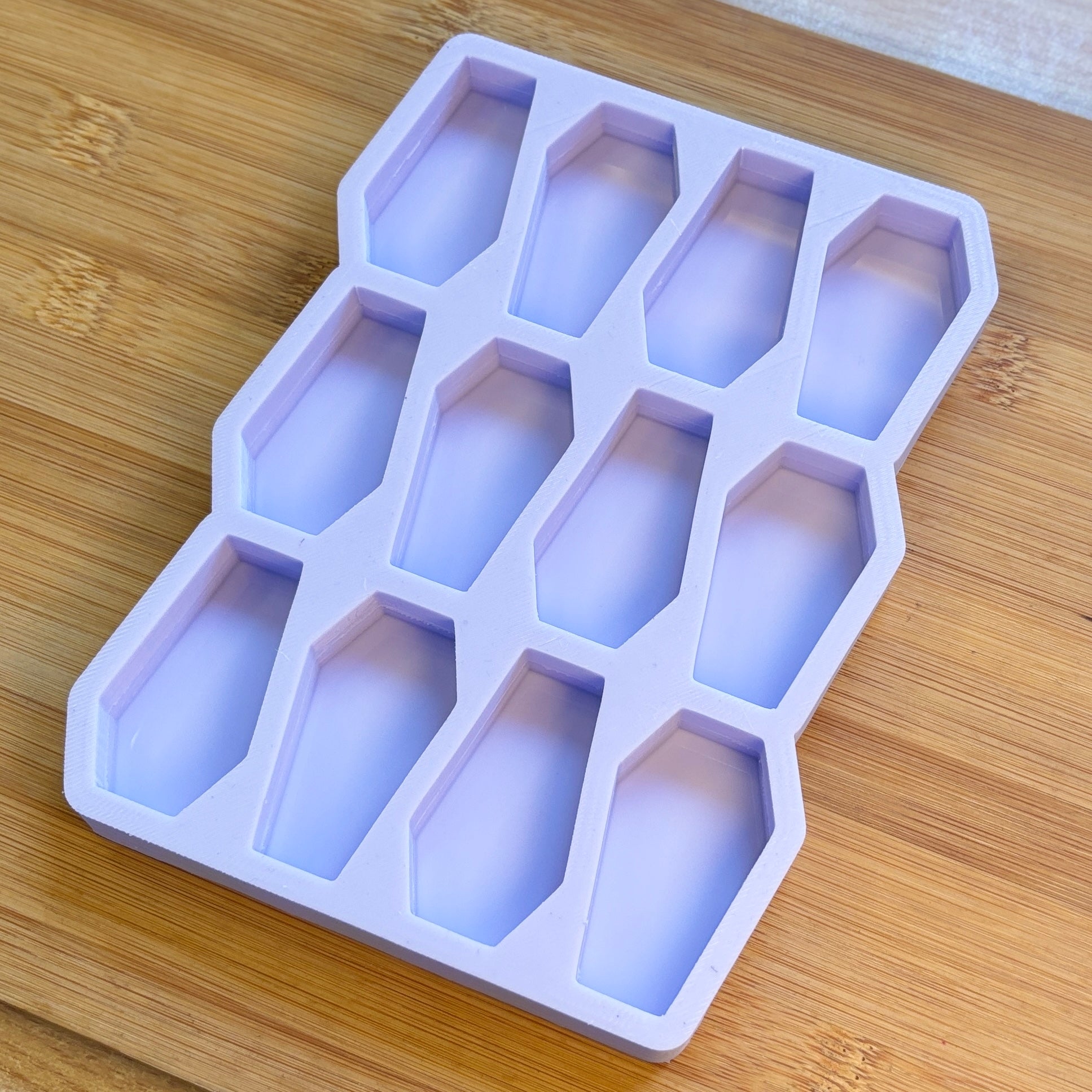 Purple silicone ice cube tray on a wooden surface