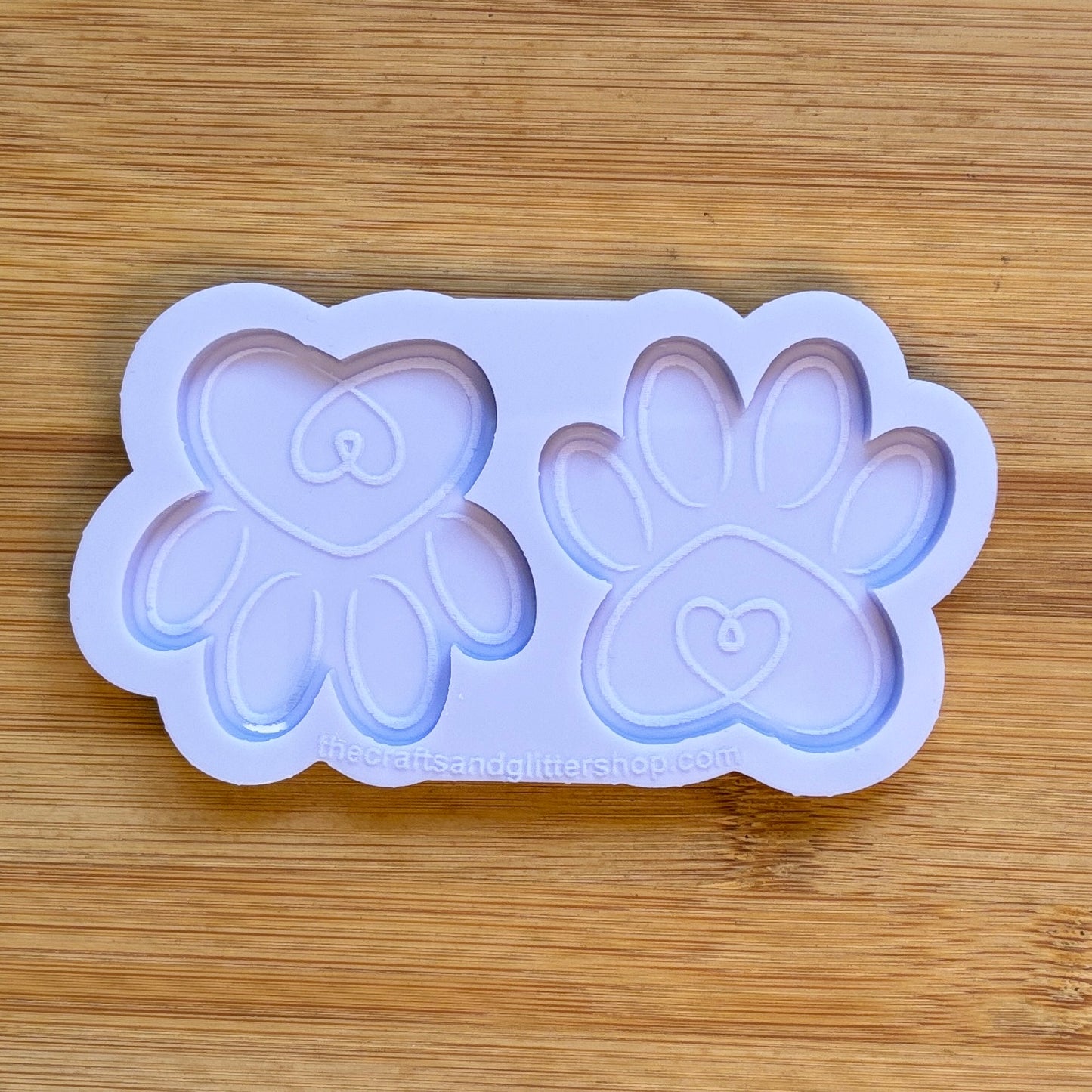 Silicone mold with heart and paw designs on a wooden surface
