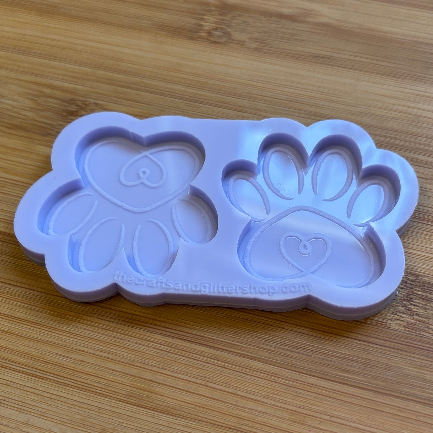 Silicone mold with heart and paw design on a wooden surface