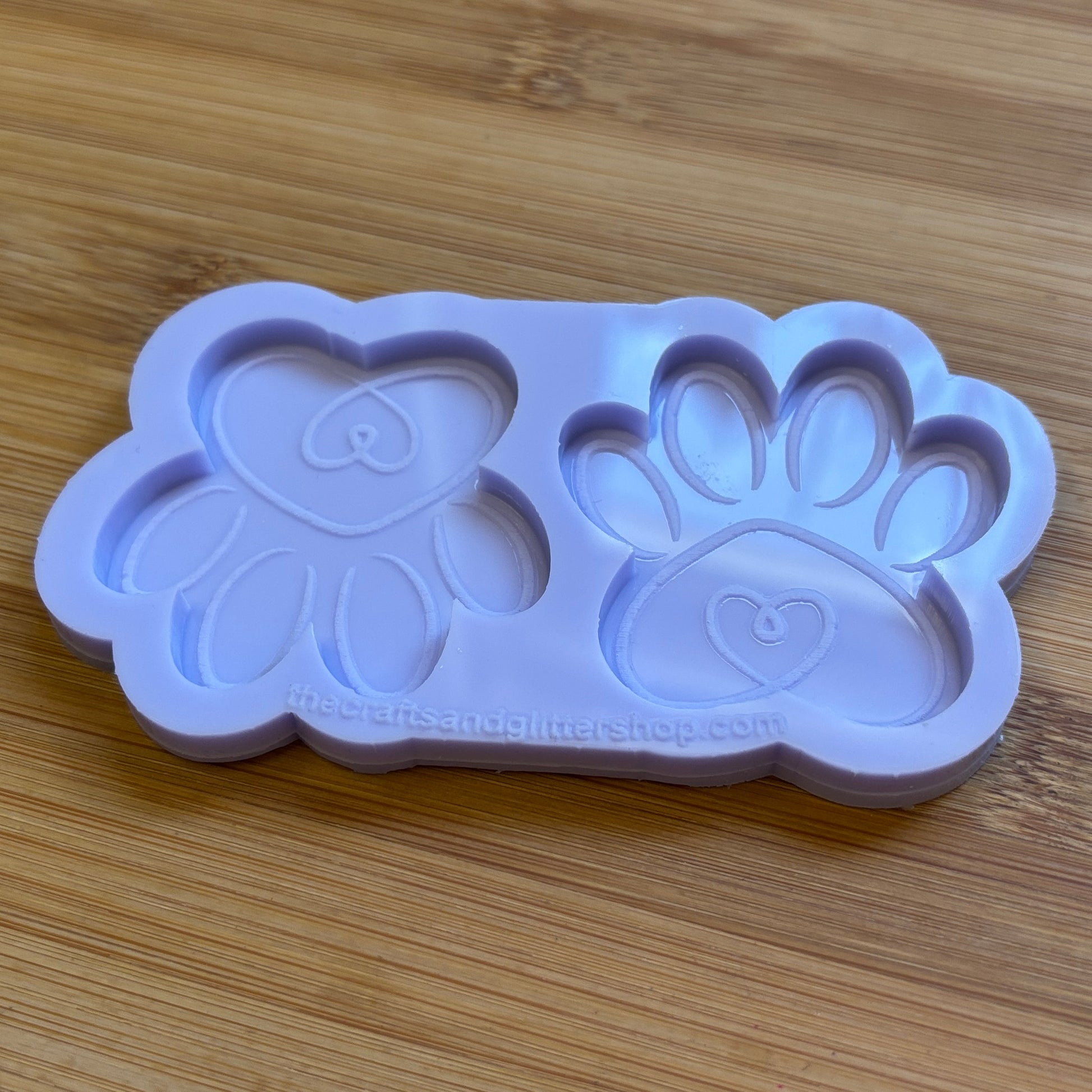 Silicone mold with heart and paw design on a wooden surface