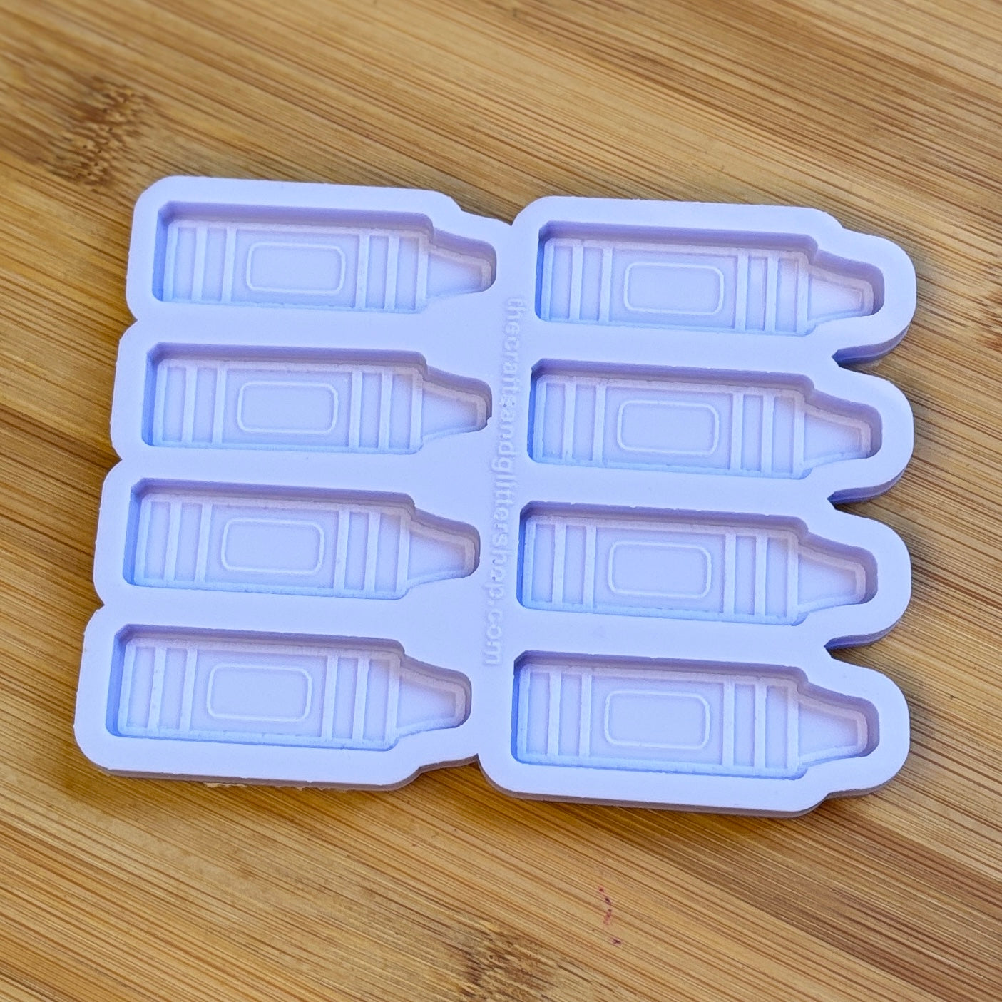 Crayon-shaped ice cube tray on a wooden surface