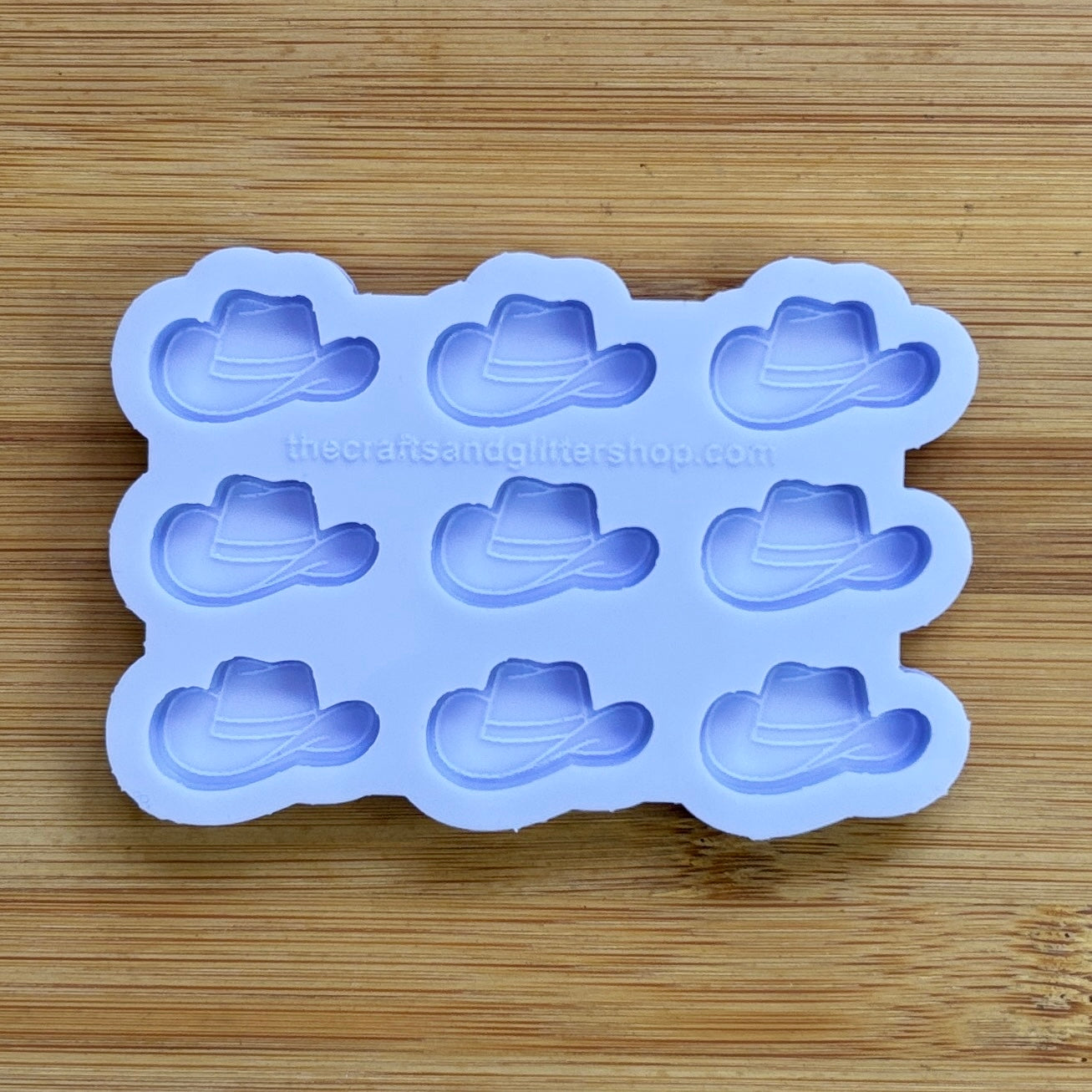 Silicone mold with cowboy hat shapes on a wooden surface
