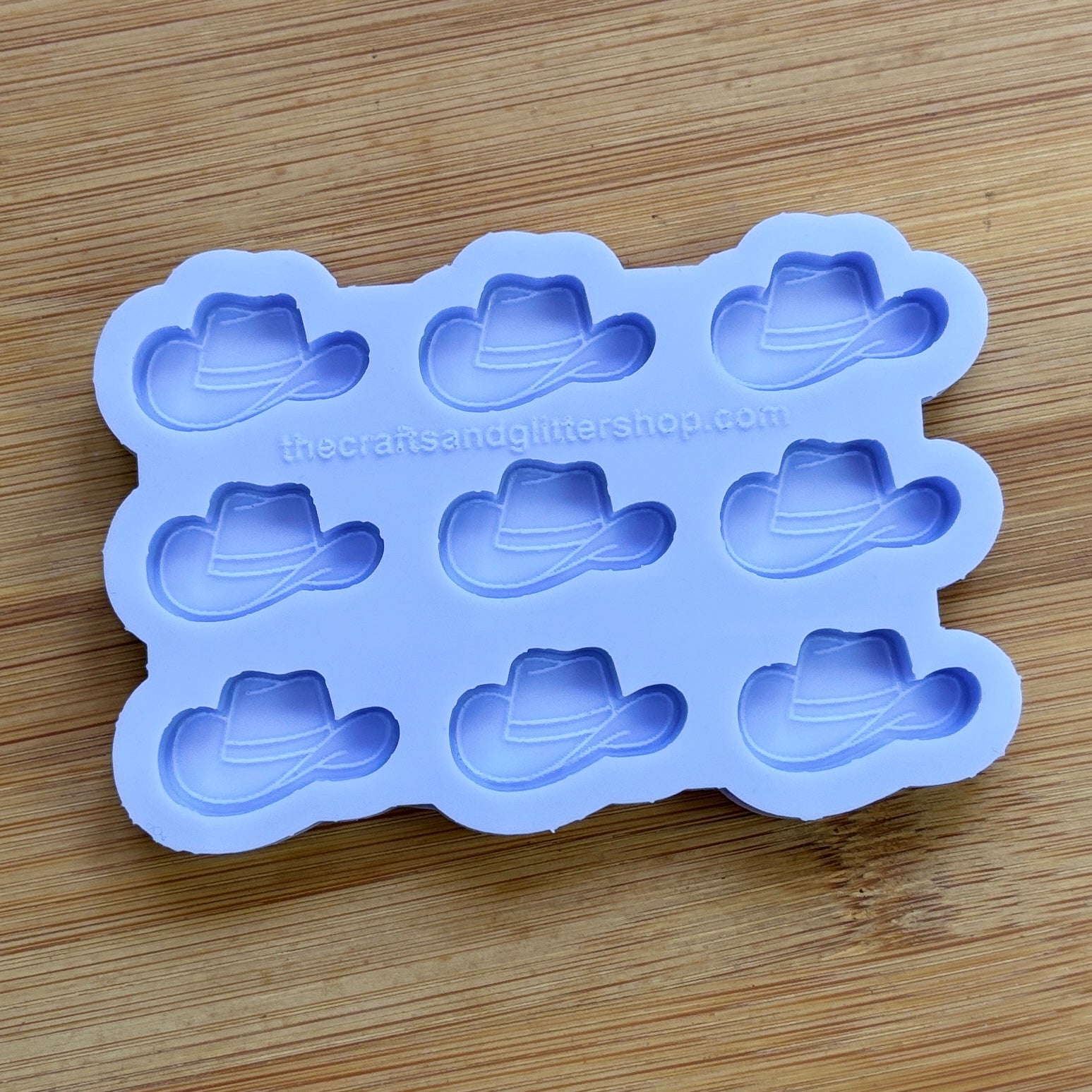 Silicone mold with cowboy hat shapes on a wooden surface