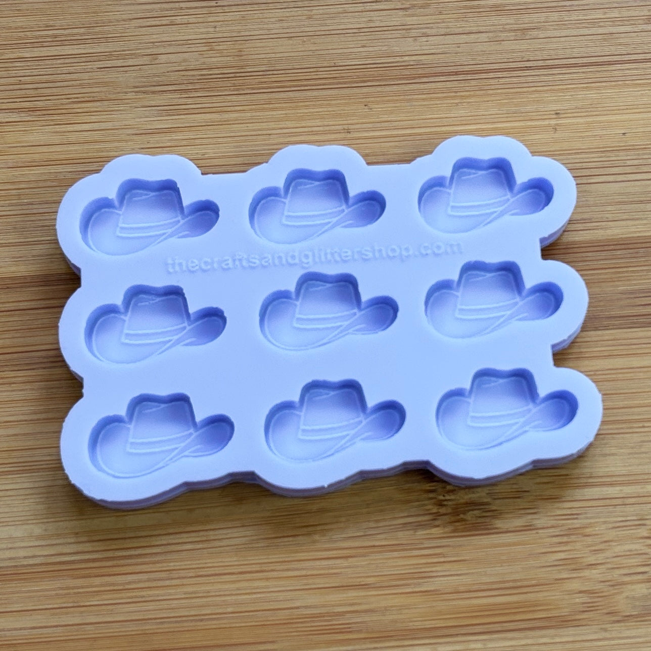 Silicone mold with cowboy hat shapes on a wooden surface