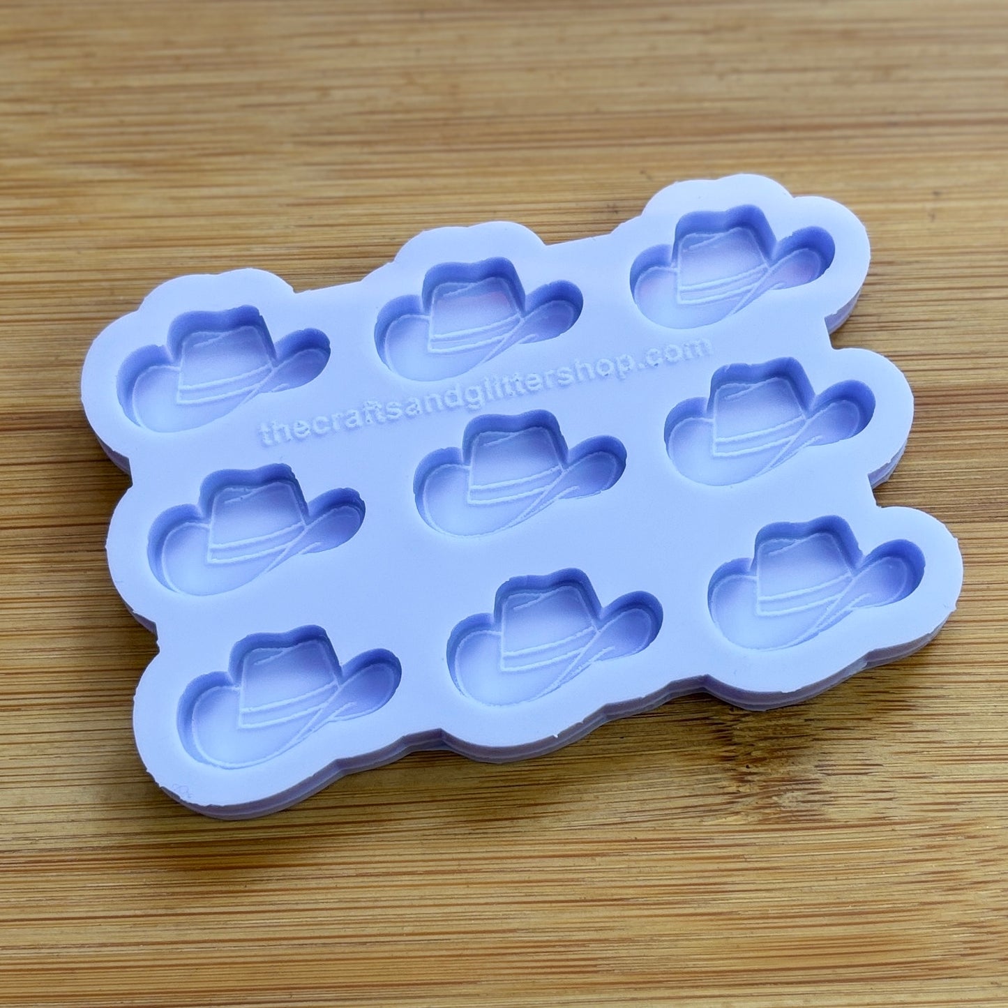 Silicone mold with cowboy hat shapes on a wooden surface
