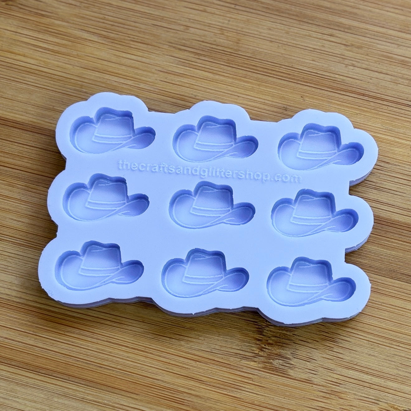 Silicone mold with cowboy hat shapes on a wooden surface