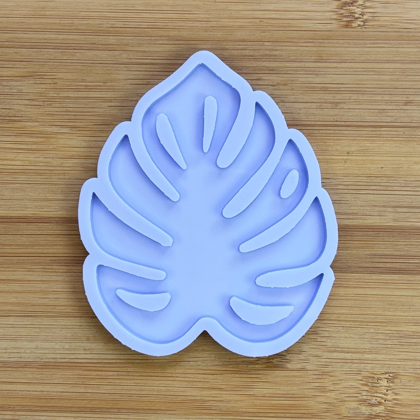 Leaf-shaped silicone mold on a wooden surface