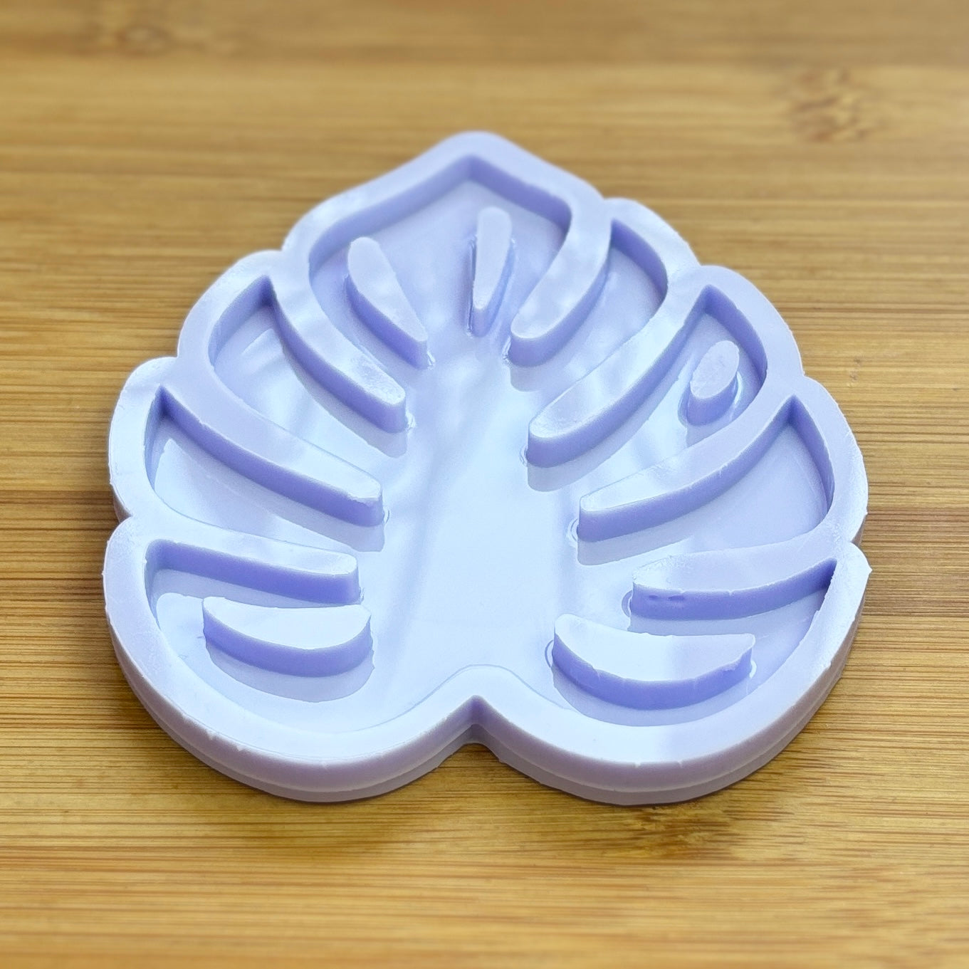 Silicone mold shaped like a leaf on a wooden surface